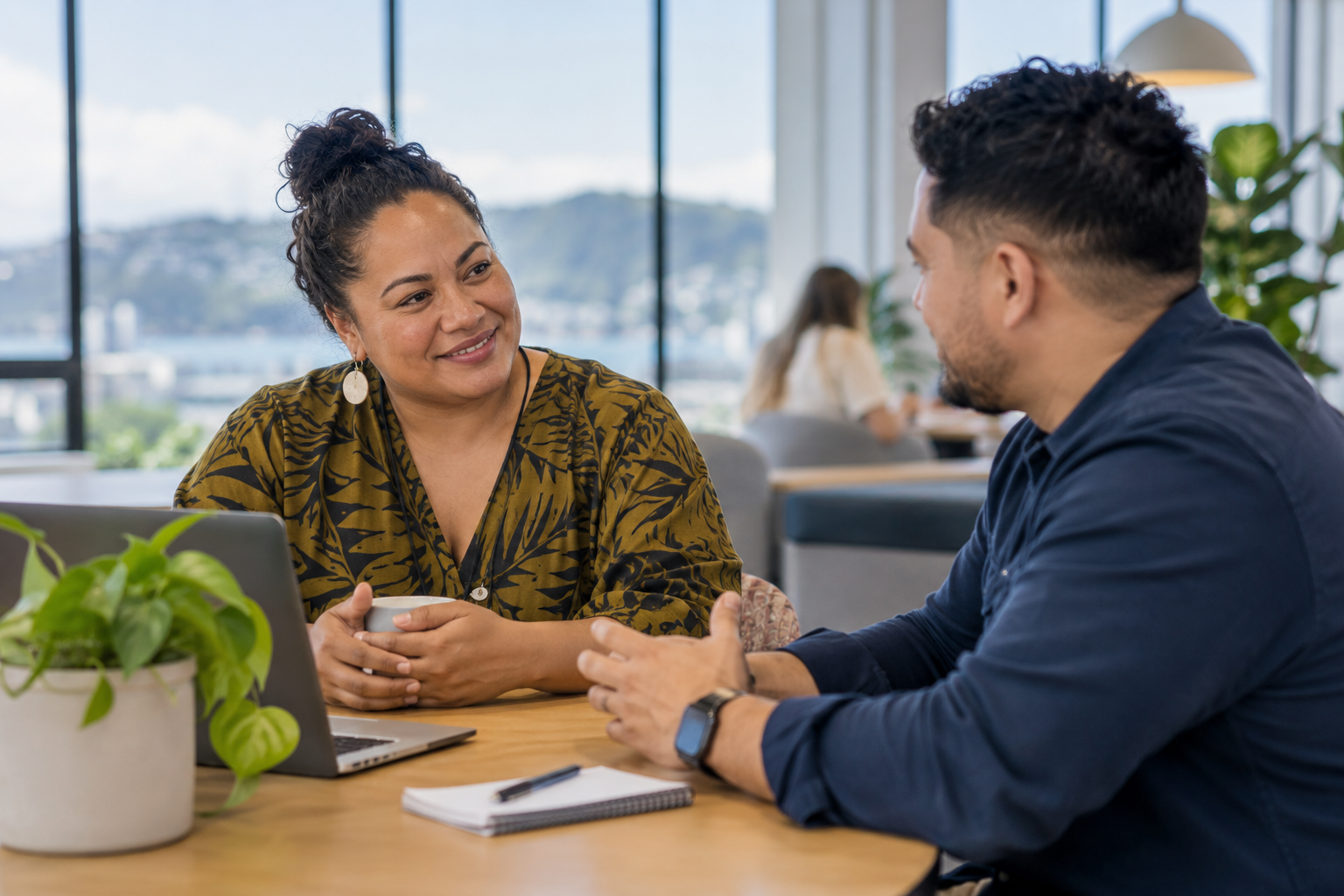 Illustrative image of two colleagues sharing a relaxed conversation in a workplace